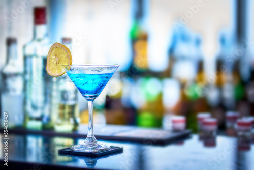 A Glass of blue cocktail and lemon slide on counter bar in rooftop bar party