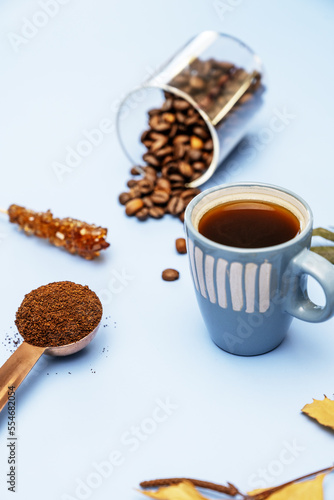 Still life with a cup of black coffee, ground coffee and roasted coffee beans in the background