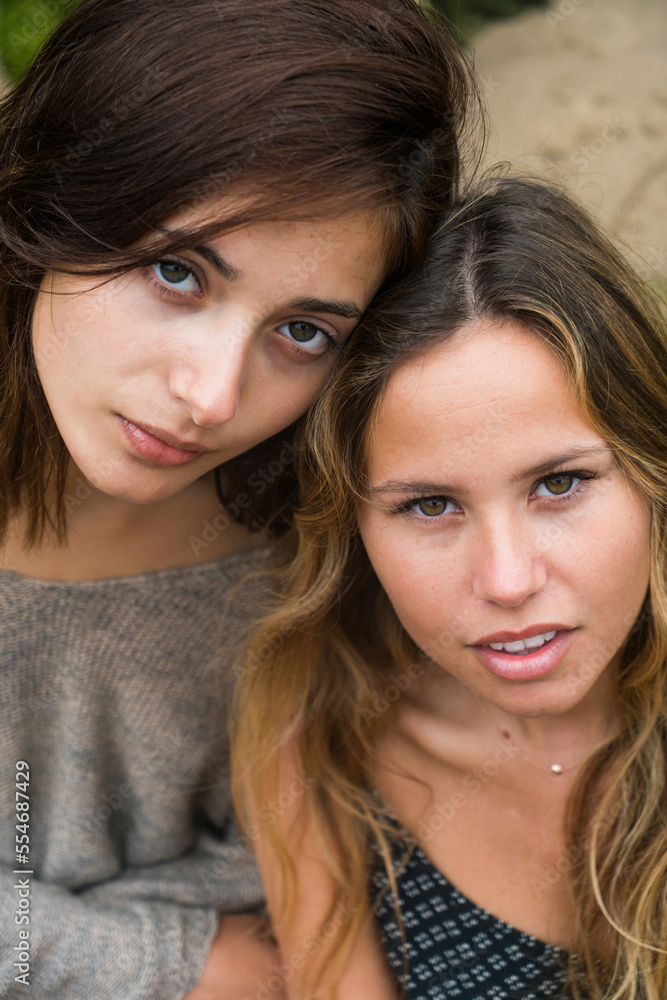 One brunette and one blonde couple of girls looking at camera in a serious way. One brunette and one blonde couple of girls looking at camera in a serious way.