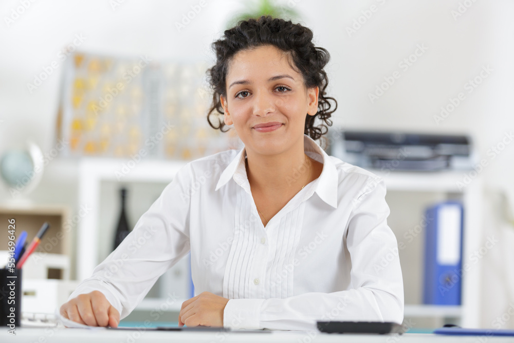 portrait of a happy casual woman at bright office desk portrait of a happy casual woman at bright office desk