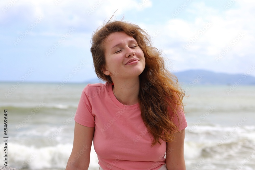 Portrait of beautiful relaxed happy positive girl, young carefree woman is enjoying sea summer vacation, smiling, looking at camera Portrait of beautiful relaxed happy positive girl, young carefree woman is enjoying sea summer vacation, smiling, looking at camera