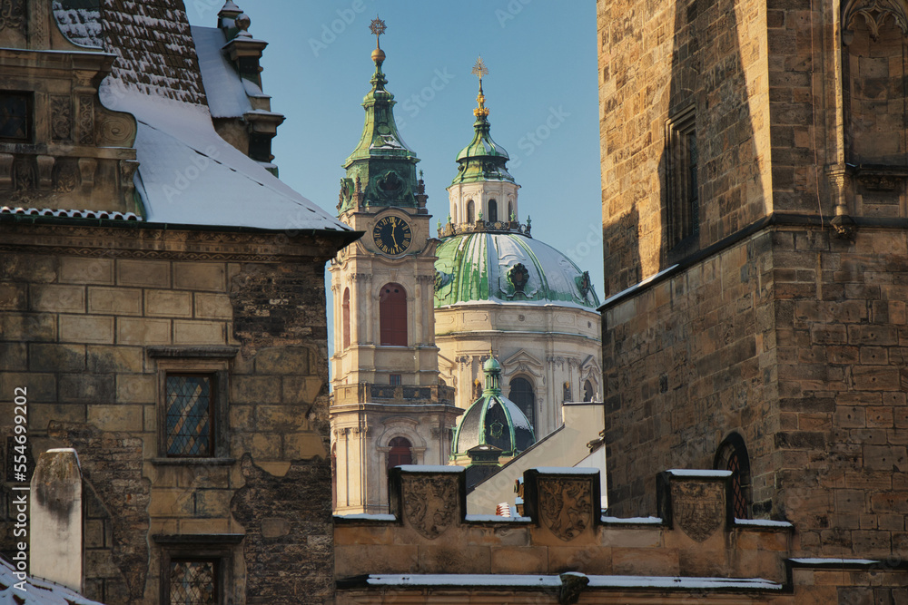 Obraz premium View from Charles Bridge with St. Nicolas Church behind Bridge Tower in winter time. Prague. Czech Republic.