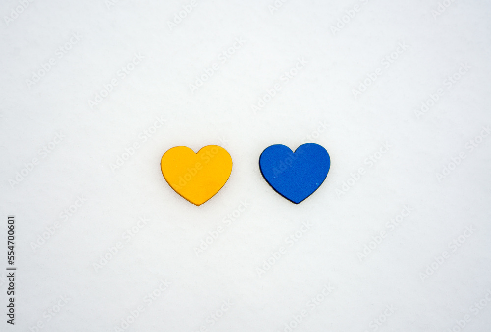 Yellow and blue hearts on a white snow