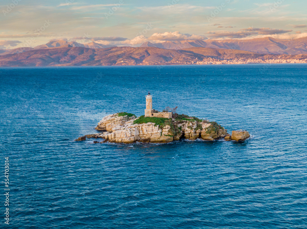 Aerial drone  view of  old Peristeres Lighthouse on mysterious rocky island in a blue sea near Corfu, Greece