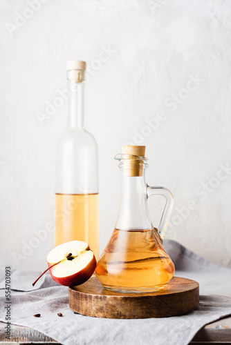 Apple cider vinegar and fresh red apples.