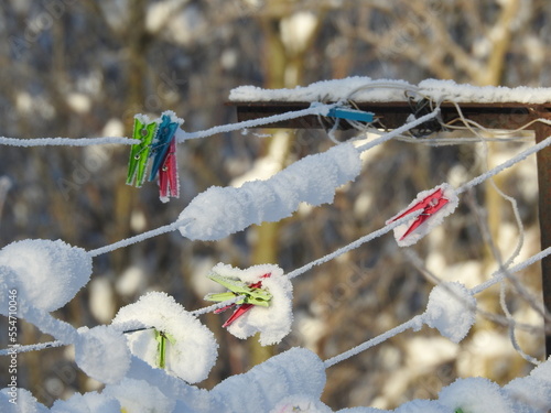 colourful clothes pegs under snow photo