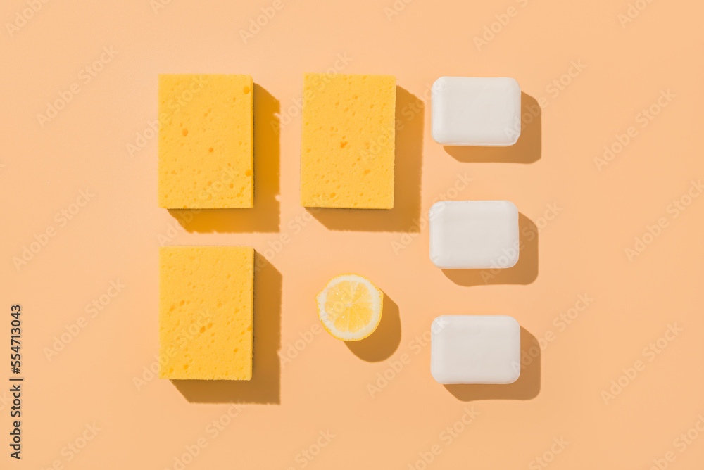 Geometric layout square pattern sponge for washing and lemon and bar of soap. Beige background.