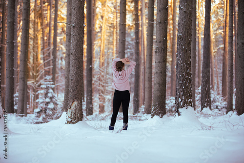 Silhouette of a woman in the forest at sunset in winter