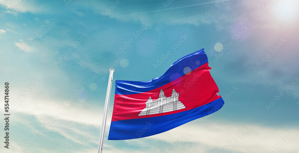 waving flag of Cambodia in blue sky. the symbol of the state on wavy cotton fabric.