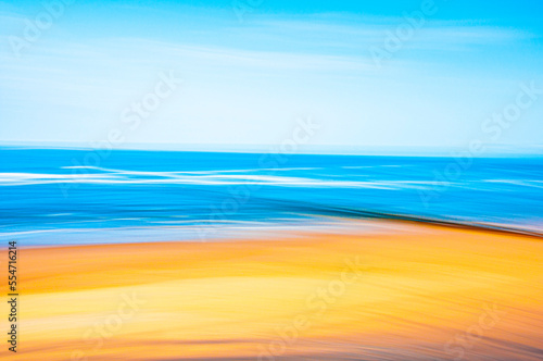 Abstract image of a serene empty beach with golden sand and azure blue water in summer