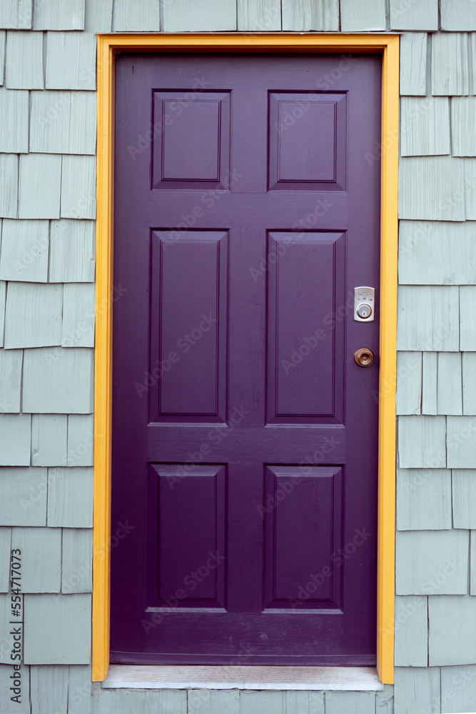 An image of a closed residential door which has been painted deep purple.