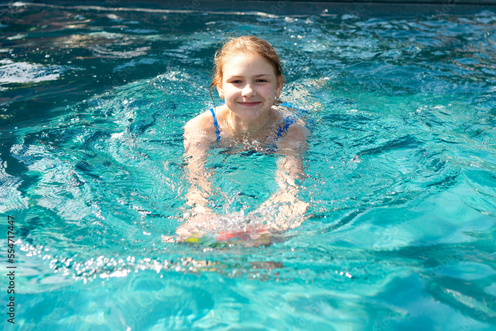 Smiling teenager girl swimming in the pool Smiling teenager girl swimming in the pool