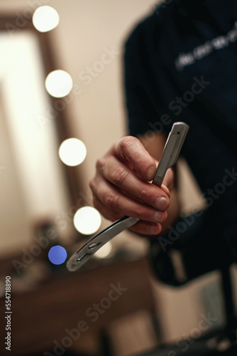 barber hand testing the sharpness of blade