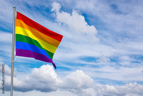 Gay Pride Flag over Blue Sky Background. 3D Illustration