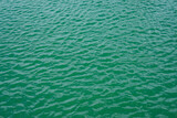 Small ripples in the calm green water
