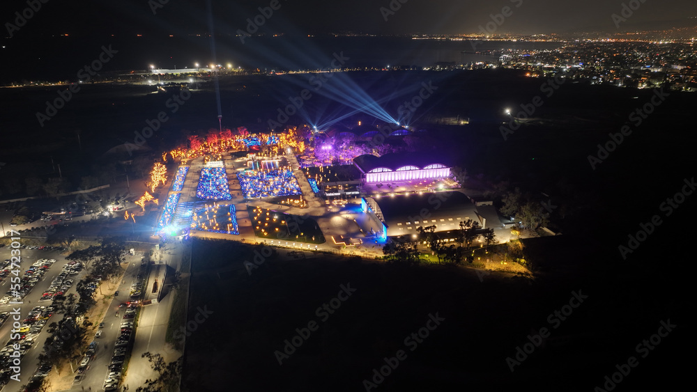 Aerial drone night distant shot from illuminated with Christmas lights futuristic Ellinikon Experience public Park an urban regeneration project and cultural center in Athens riviera, Attica, Greece