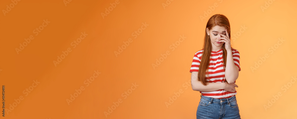 Annoyed redhead woman fed up listening stupid nonsense, close eyes tired, make face palm embarrassed uninterested, feel uneasy distressed, exhausted useless argument, irritated orange background - obrazy, fototapety, plakaty 