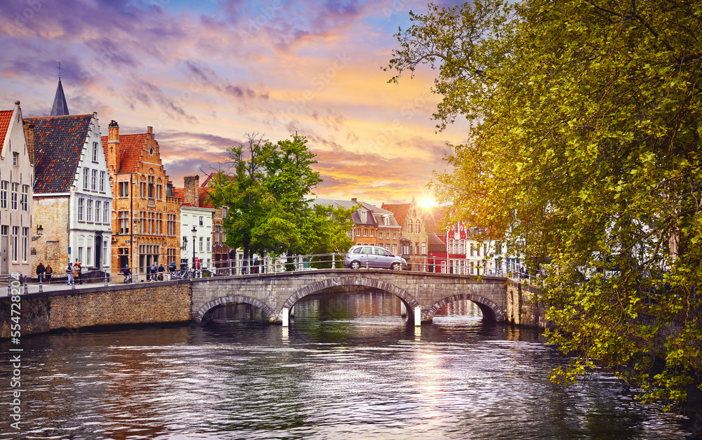 Bruges Belgium. Old town with vintage houses and stone bridge on the river sunset sky. Picturesque landmark in Europe