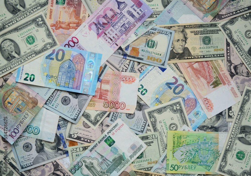 Flat lay. On the table, there are money from different countries, dollars, euros, Russian rubles, Belarusian rubles. A lot of banknotes lie nearby. Top view, close-up. Flat lay. On the table, there are money from different countries, dollars, euros, Russian rubles, Belarusian rubles. A lot of banknotes lie nearby. Top view, close-up.