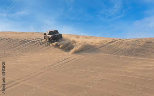 Desert Safari, a black SUV is bashing through the arabian sand dunes in Doha, Qatar © Arnold