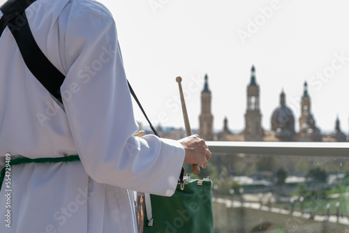 Valokuva Chica vestida de cofrade en una terraza mirando al pilar demostrando su devoción
