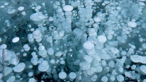 Frozen methane bubbles and cracks in the ice on Lake Baikal Siberia Russia. Natural cold background of ice. Winter abstract background. High quality 4k footage