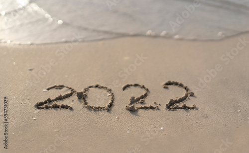 The numbers 2022 are washed away by the sea waves of the Persian Gulf. The concept of a change of years