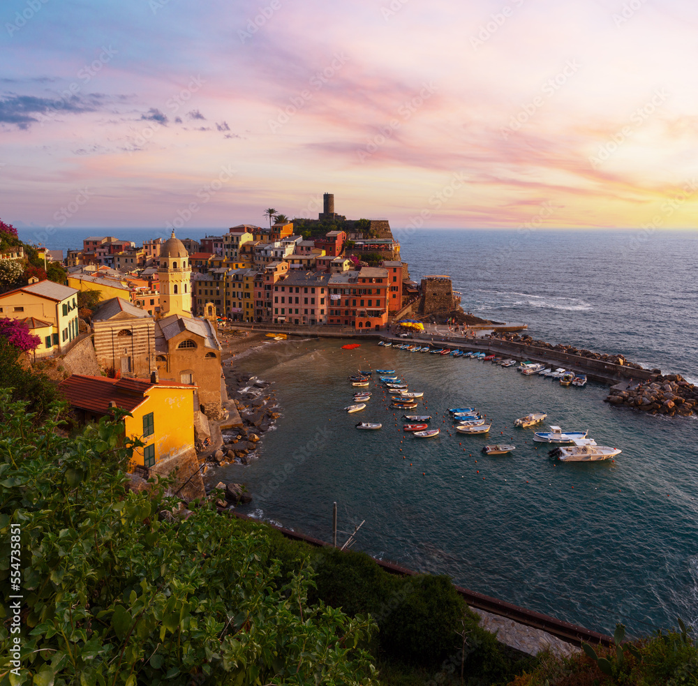 Beautiful sunset in summer Vernazza - one of five famous villages of Cinque Terre National Park in Liguria, Italy, suspended between Ligurian sea and land on sheer cliffs.