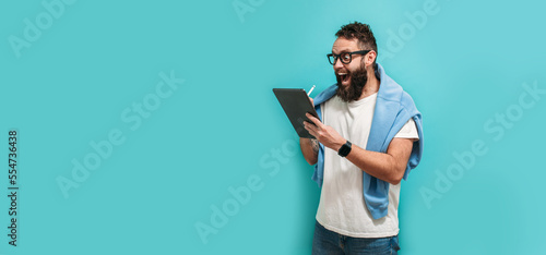Fotografie, Tablou Professional designer working on digital tablet computer using stylus pen isolated over blue color background