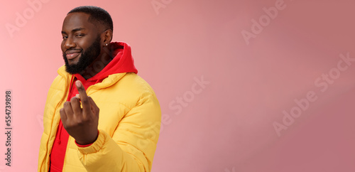 Cheeky flirty black bearded guy asking come closer beckon index finger camera smiling make smug face have plans for you alluring join, standing pink background devious grin photo