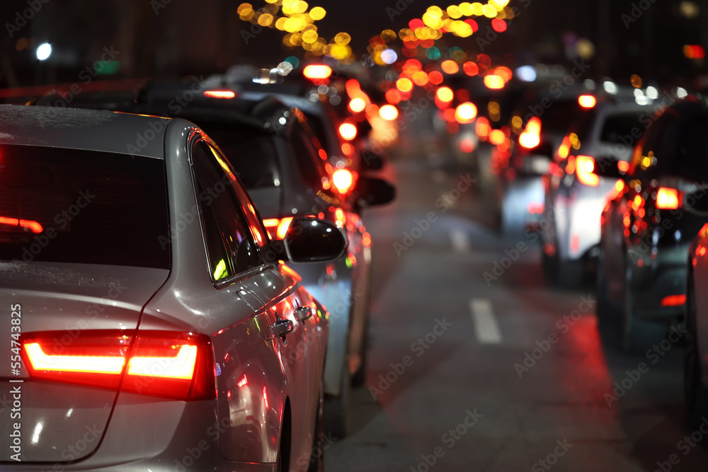 Bliki lamp ulicznych i Samochody stoją w mieście w czasie wieczornego szczytu w korku przed świętami zimowymi. - obrazy, fototapety, plakaty 