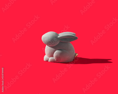 Chinese New Year 2023 concept. Rabbit on a red background. Minimalistic Year of Rabbit composition.
