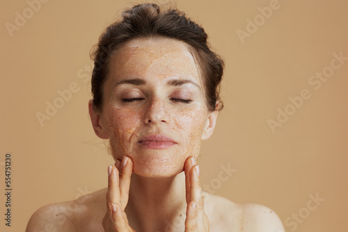 modern woman with face scrub isolated on beige