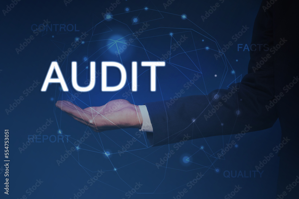Audit concept. Businessman holding digital word in hand and scheme on blue background, closeup Audit concept. Businessman holding digital word in hand and scheme on blue background, closeup