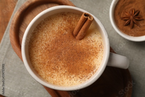 Delicious eggnog with anise and cinnamon on wooden table, top view