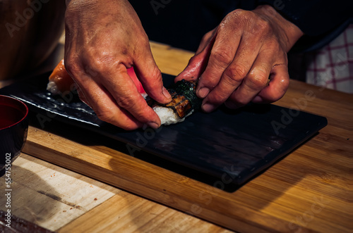 Japanese chef making rice nigiri sushi with tuna, salmon, shrimp,traditional Japanese food ,Dark Tone