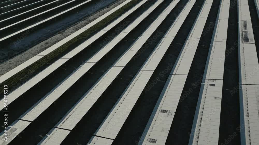 Solar panels of photovoltaic power plant covered in snow, aerial drone shot Solar panels of photovoltaic power plant covered in snow, aerial drone shot
