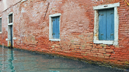 An ancient brick wall with shuttered windows, along one of Venice's famed canals. © Don Masten II