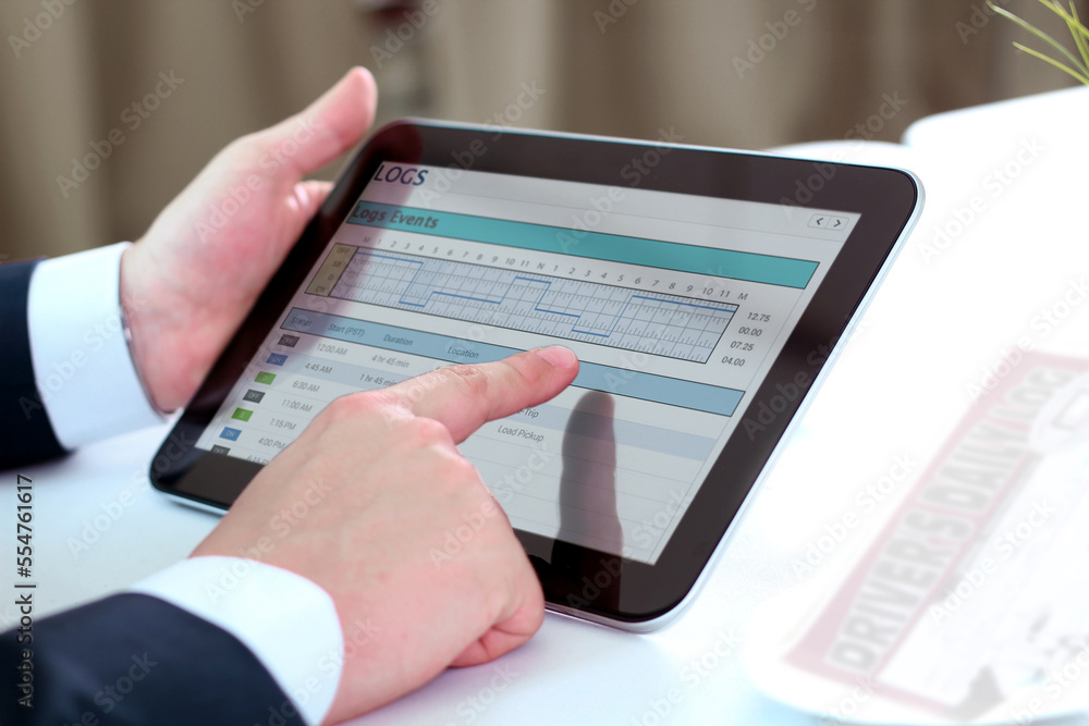 Safety manager is showing to Truck driver  electronic logbooks on a tablet