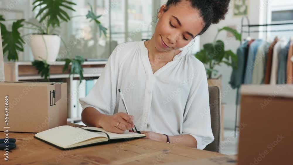 Black woman, writing in notebook and fashion studio, creative planning or delivery package for supply chain manager. African woman, clothes boutique and creativity idea vision in designer office Black woman, writing in notebook and fashion studio, creative planning or delivery package for supply chain manager. African woman, clothes boutique and creativity idea vision in designer office