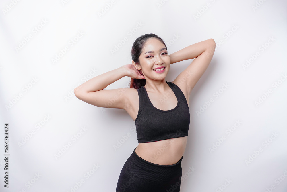 Portrait of young Asian sporty woman wearing sportswear is stretching out before training.