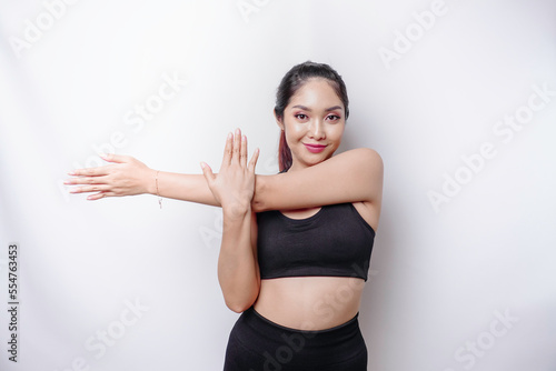 Portrait of young Asian sporty woman wearing sportswear is stretching out before training.