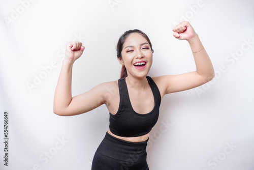 A young sporty Asian woman with a happy successful expression wearing sportswear isolated by white background