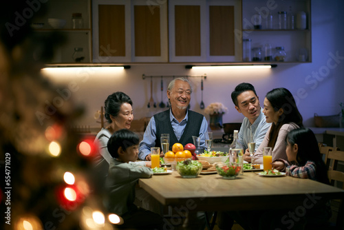 three generation asian family having christmas dinner together at home