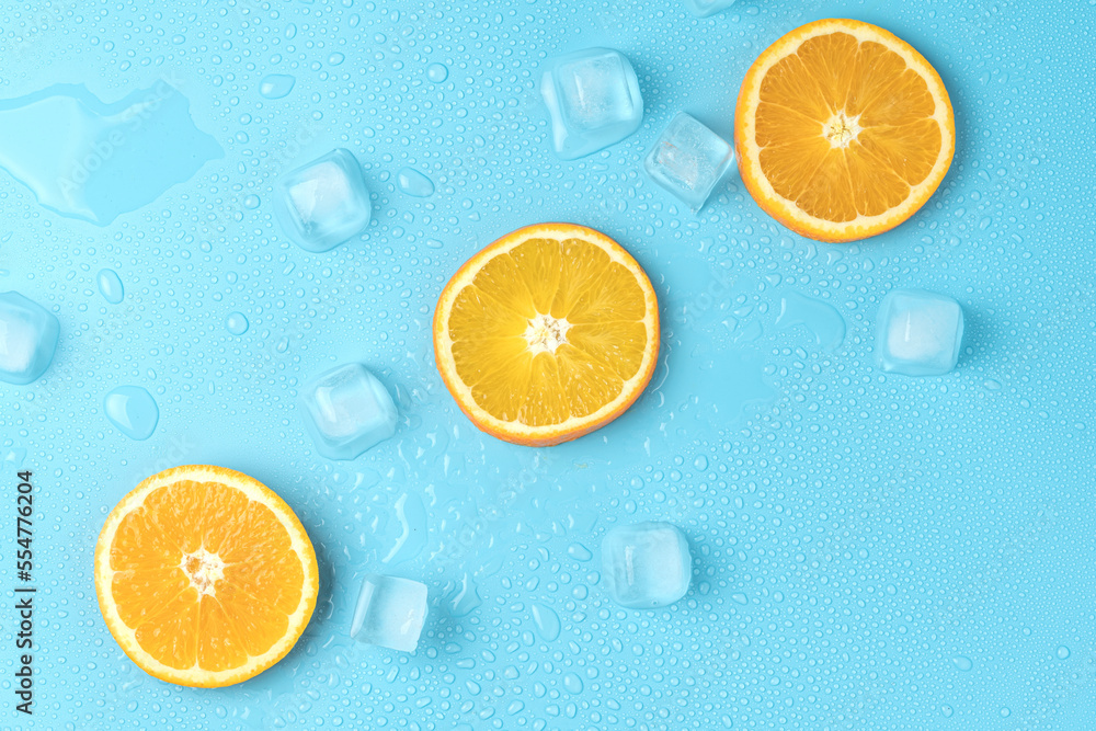 Juicy oranges on a background of ice cubes with copy space on a blue background Juicy oranges on a background of ice cubes with copy space on a blue background