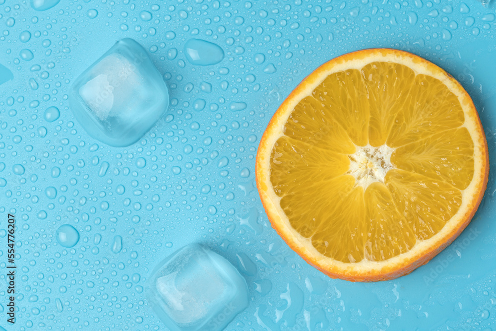 Juicy oranges on a background of ice cubes with copy space on a blue background Juicy oranges on a background of ice cubes with copy space on a blue background