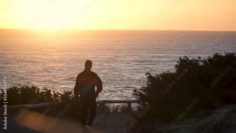 Slow Motion Shot Of Man Walking Towards Sea At Sunset, Cadiz, Spain Slow Motion Shot Of Man Walking Towards Sea At Sunset, Cadiz, Spain