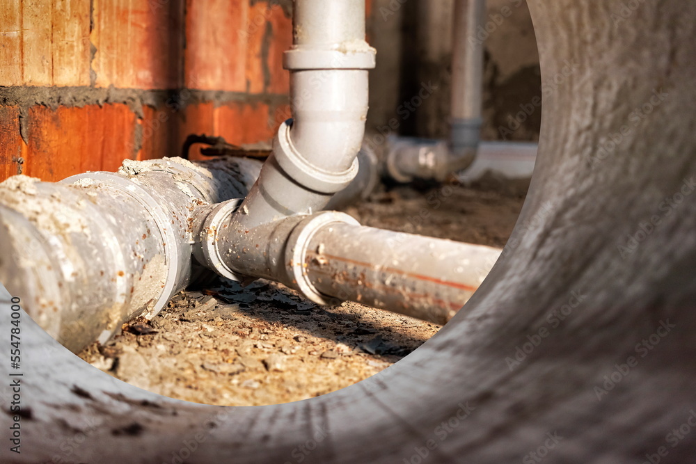Sewer pipes in home basement. System of gray sanitary pipes when building a house. Sewer