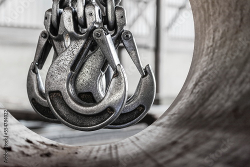 Lifting mechanism iron chain with a hook of an overhead crane on the background of an industrial enterprise or factory.