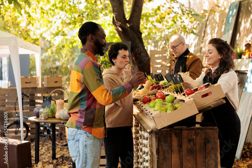 Canvas Print Man and woman receiving fruits samples at farmers market, checking homegrown fruits and veggies at local farmers market